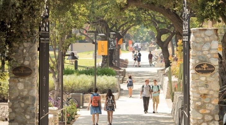 Pitzer College gates with students walking